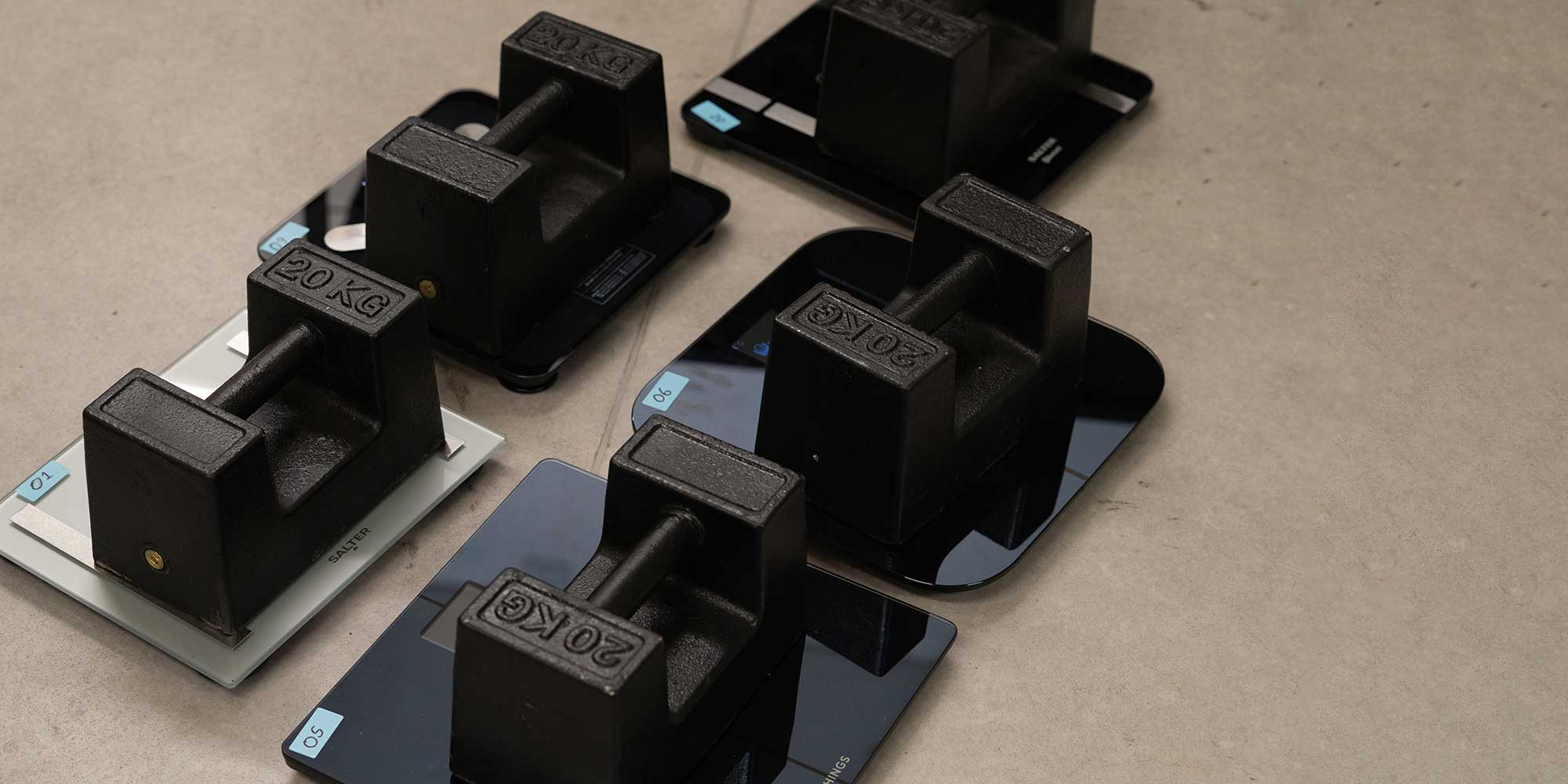 A series of 20kg weights on top of some scales